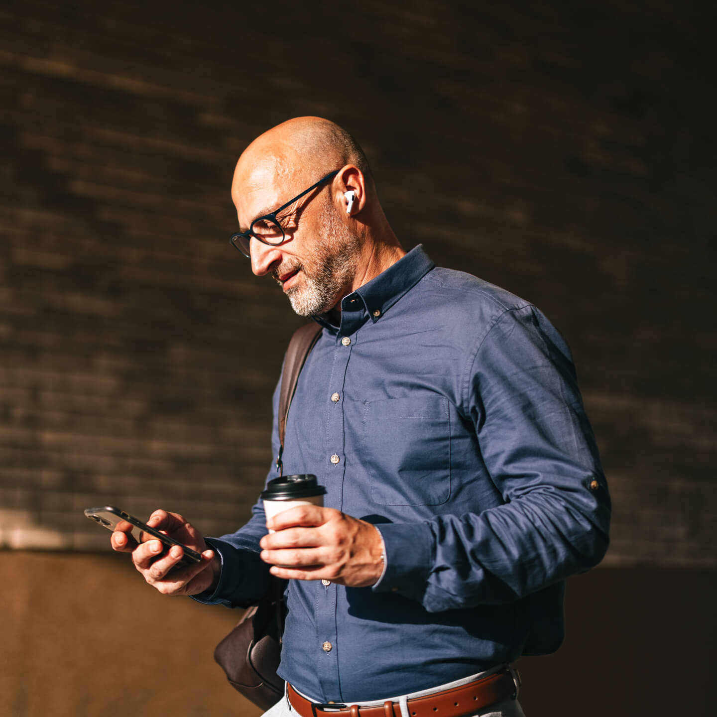 Man walking outside looking at phone